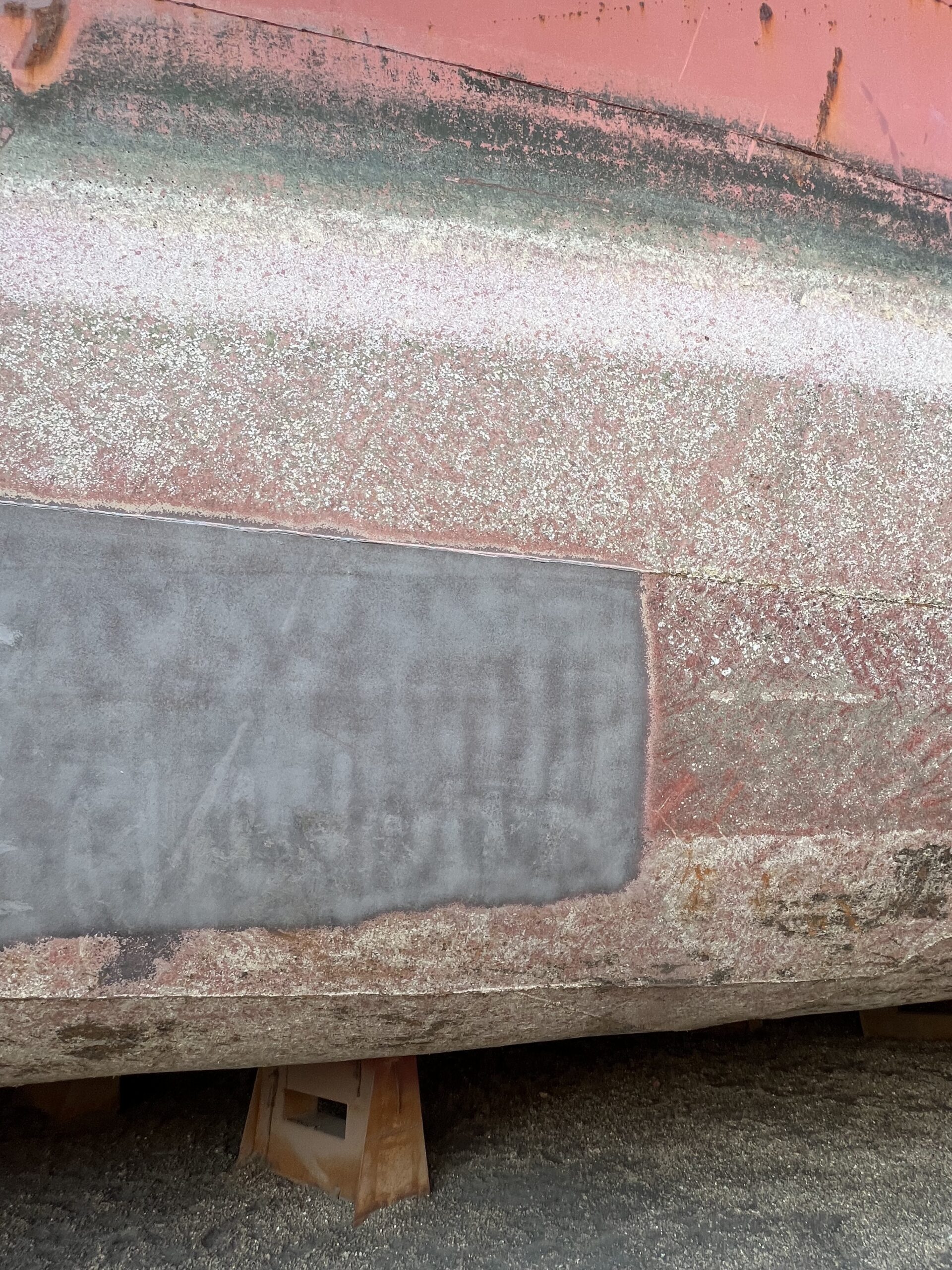 [Image placeholder: Close-up shots of various surface preparation stages: cleaning, sanding a hull, a properly abraded surface ready for priming.]